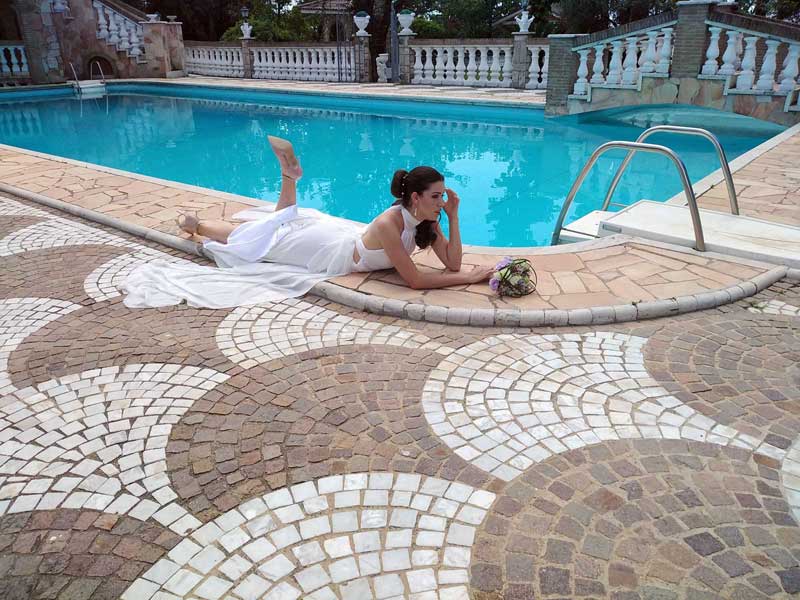 immagine con modella vestita di bianco vicino una piscina